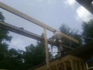 Carpenter setting a ridge beam over a new addition frame — Ice Dam Removal by Roofing Brothers in McCall