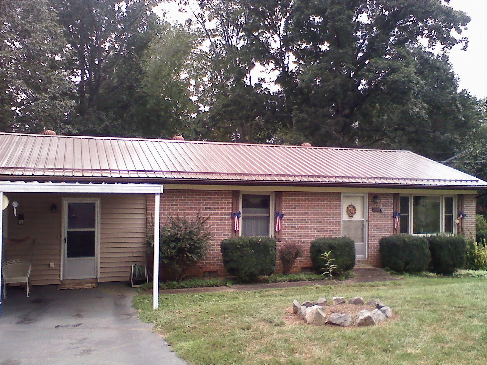 Bronze metal roof and carport on a brick ranch home — Roof Repair work by our crew in McCall